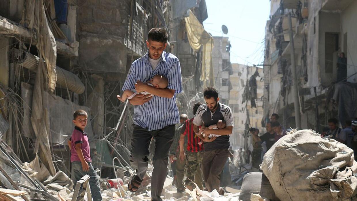 Resultado de imagen para Un hombre carga un bebé tras un ataque en la norteña ciudad siria de Alepo.