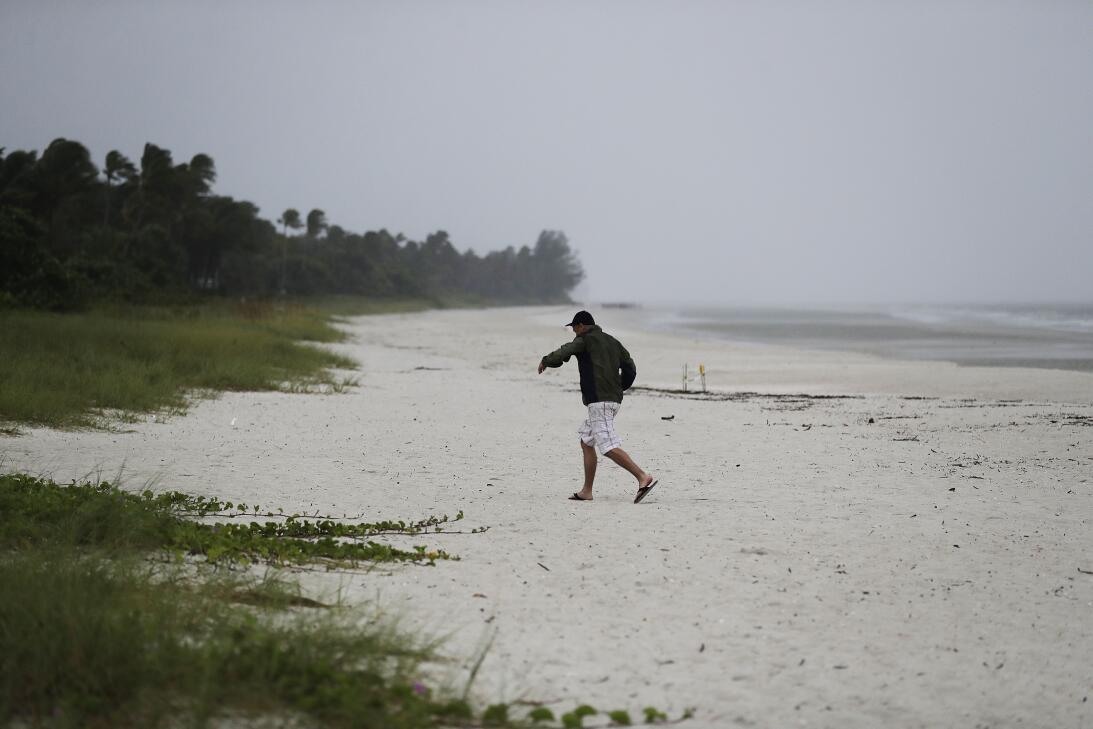 A beachgoer runs off the beach as the early effects of Hurricane Irma pi...