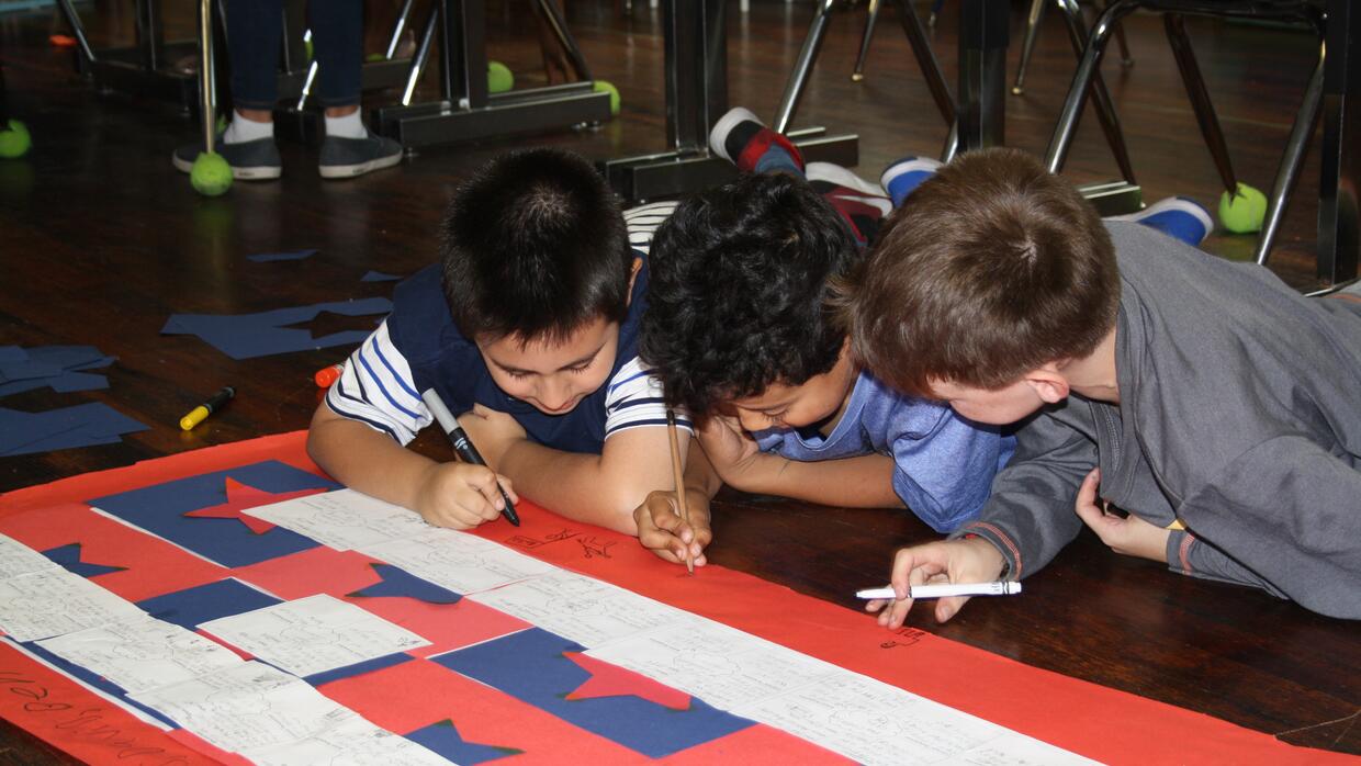 Tres estudiantes colaboran en un proyecto en la Escuela Bilingüe Oyster-...