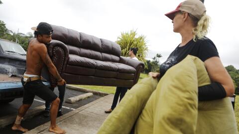 Elijah Guerra (izquierda) ayuda a una de las evacuadas, Stacy Welch, a s...