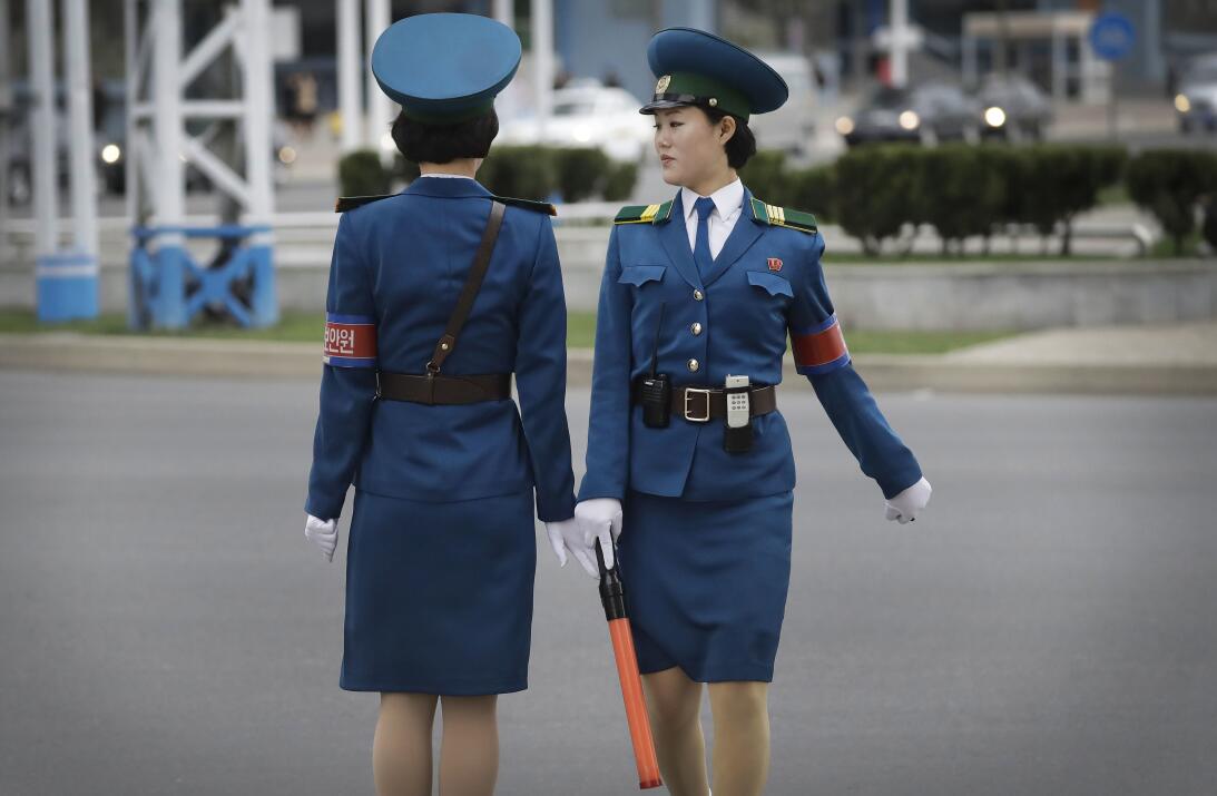 Se mueven con gracia, con entallados uniformes azules y tacones bajos en...