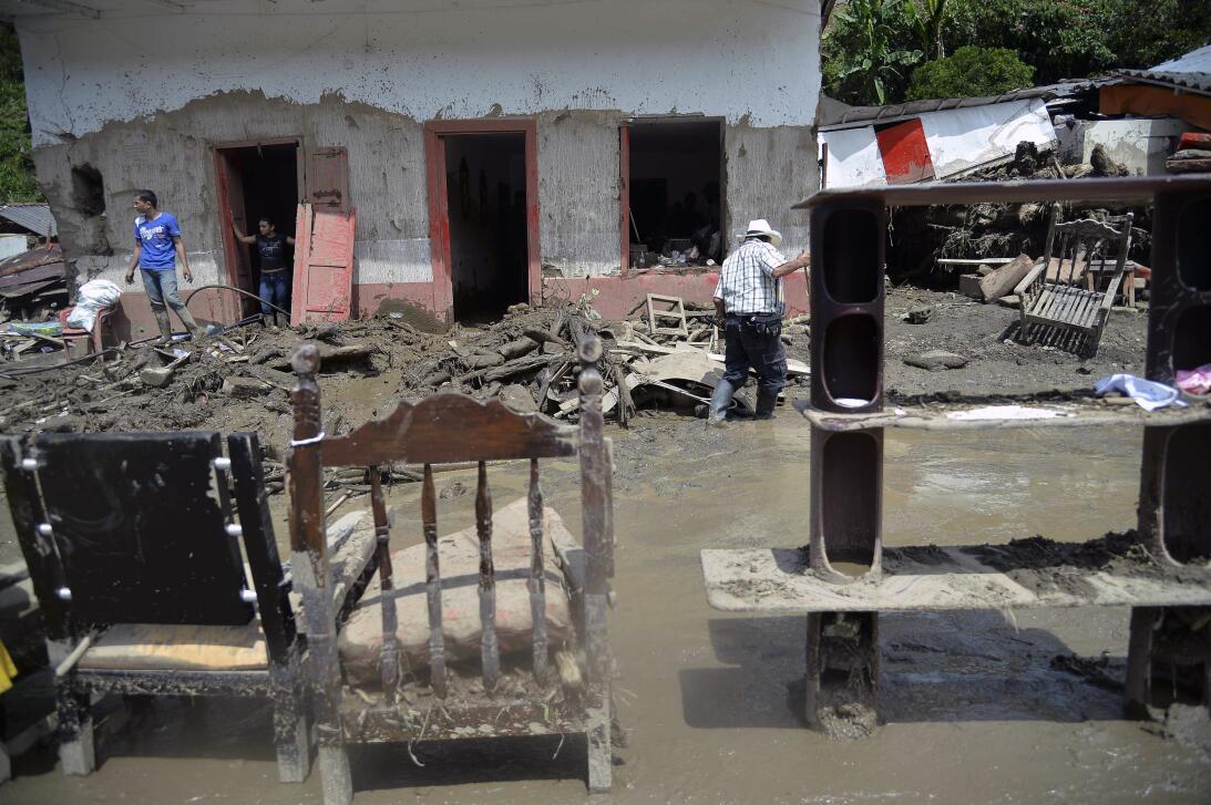 People try to save their belongings after a landslide in Salgar municipa...